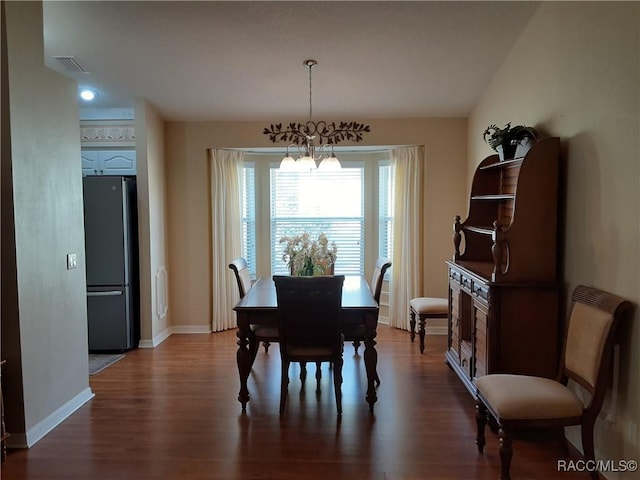 dining room featuring dark hardwood / wood-style flooring and a chandelier