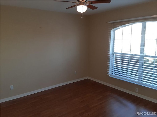 unfurnished room featuring ceiling fan and dark wood-type flooring