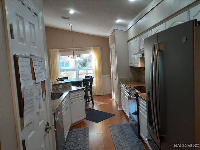 kitchen featuring white cabinets, decorative light fixtures, stainless steel appliances, and an inviting chandelier