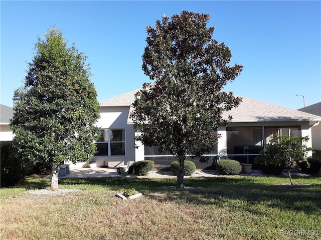 view of front of home with a sunroom and a front yard