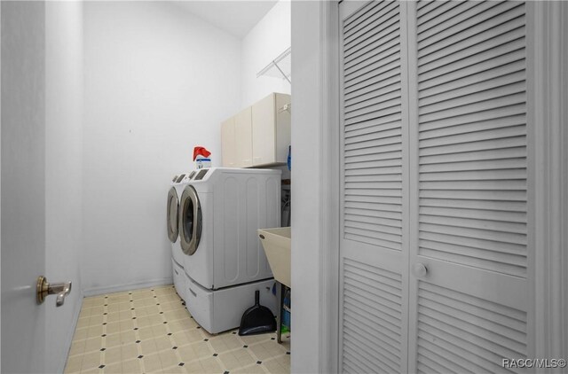 laundry area featuring washer and dryer, light floors, and cabinet space
