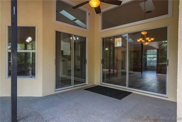 doorway to property featuring stucco siding and a ceiling fan