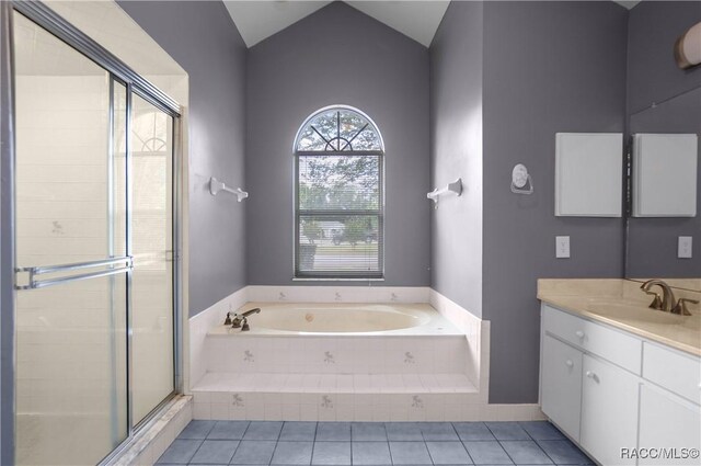 full bath featuring tile patterned floors, vaulted ceiling, vanity, a stall shower, and a garden tub