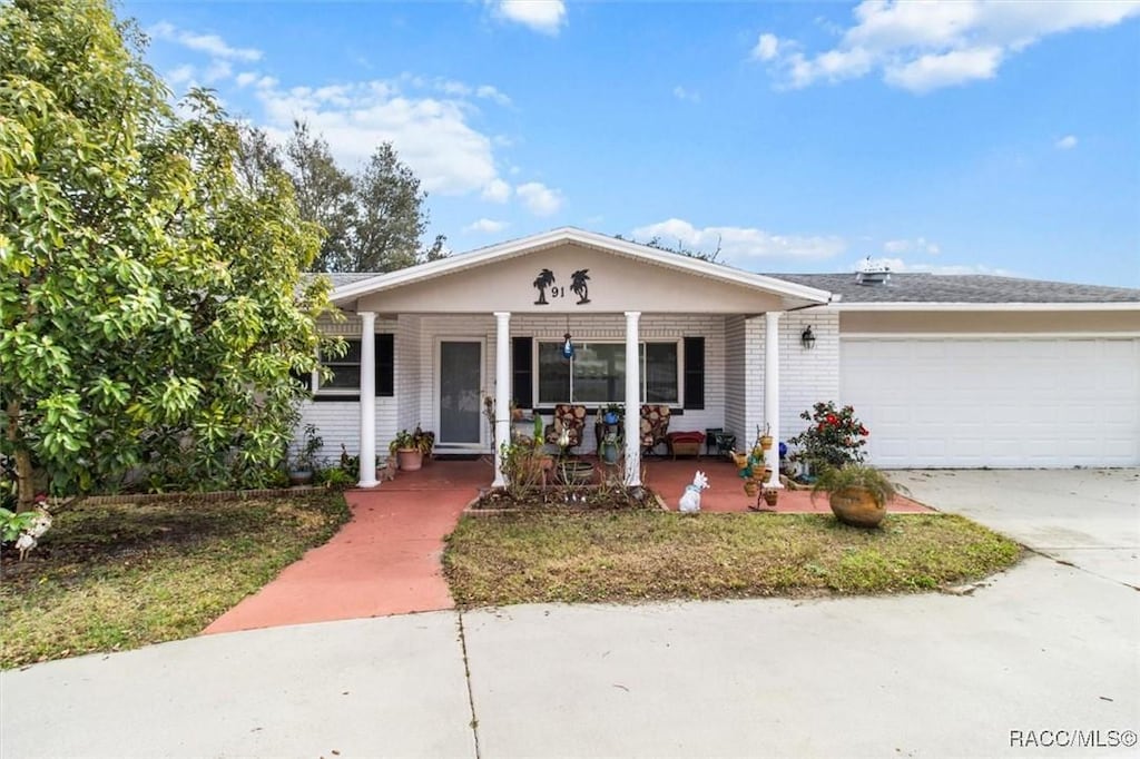 ranch-style house featuring a garage and covered porch