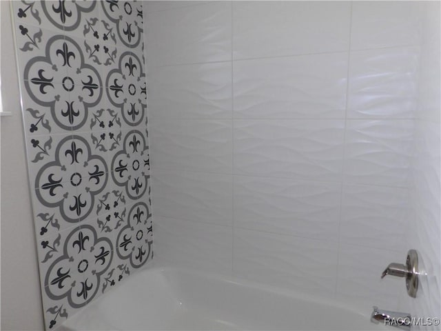 bathroom featuring tiled shower / bath