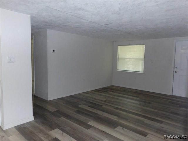 empty room with wood finished floors and baseboards