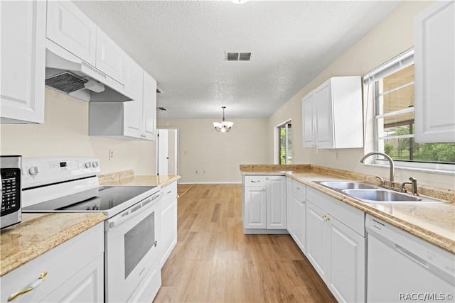 kitchen featuring pendant lighting, white cabinets, and white appliances