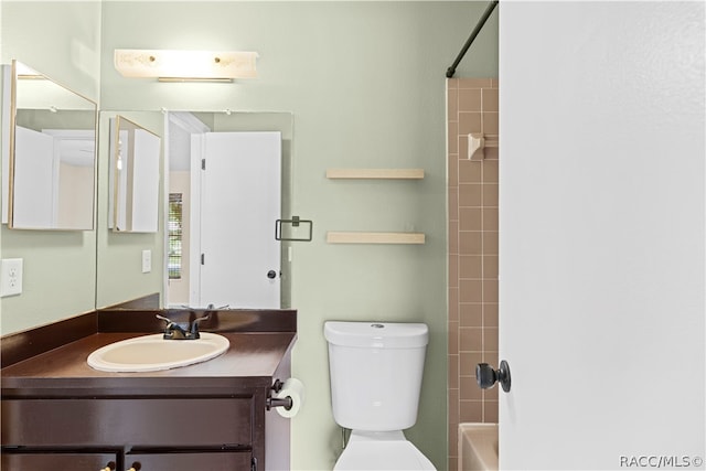 full bathroom featuring tiled shower / bath combo, toilet, and vanity