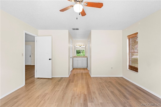 interior space featuring a textured ceiling, light hardwood / wood-style floors, and ceiling fan