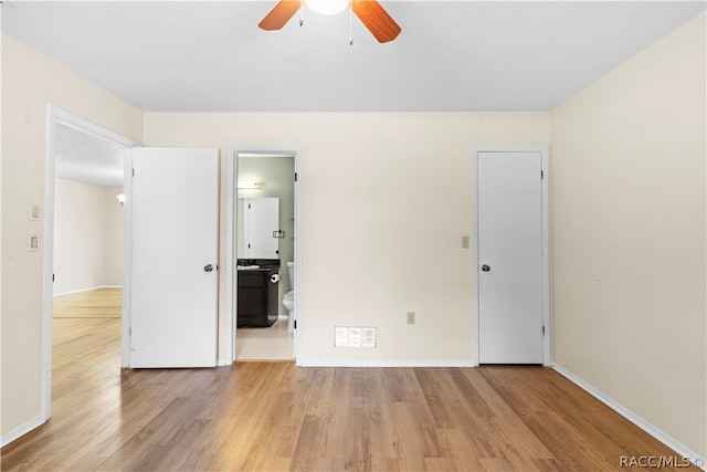 unfurnished bedroom with ceiling fan, light hardwood / wood-style floors, a textured ceiling, and ensuite bath