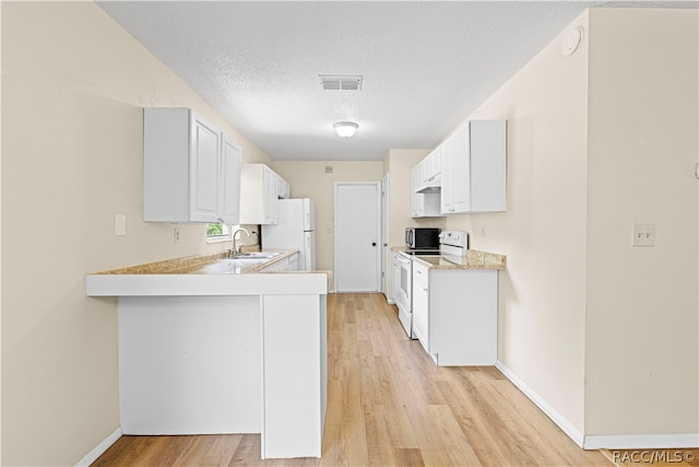 kitchen with white cabinetry, sink, a textured ceiling, white appliances, and light wood-type flooring