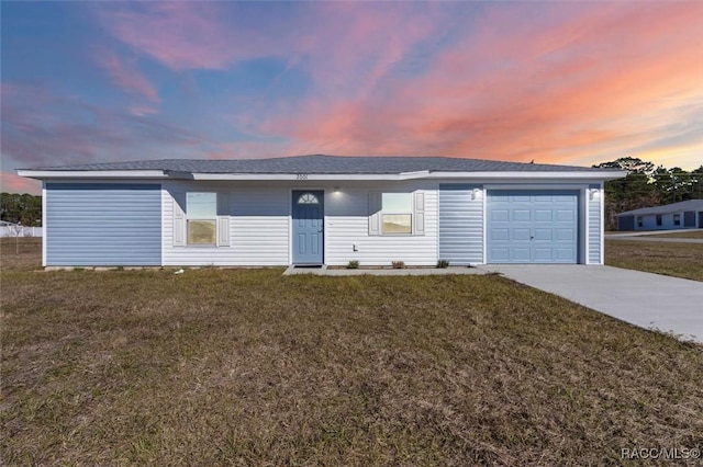 ranch-style house with a garage and a lawn