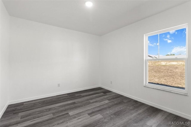 spare room with dark wood-type flooring