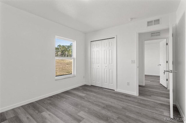 unfurnished bedroom with a closet and wood-type flooring