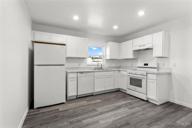 kitchen featuring hardwood / wood-style flooring, sink, white appliances, and white cabinets