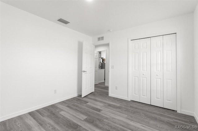 unfurnished bedroom with light hardwood / wood-style floors and a closet