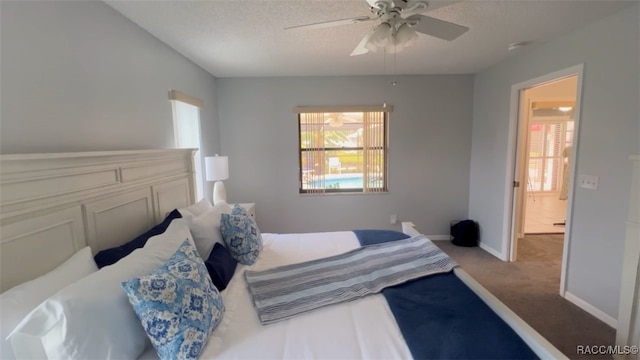 bedroom with a textured ceiling, ceiling fan, and light carpet