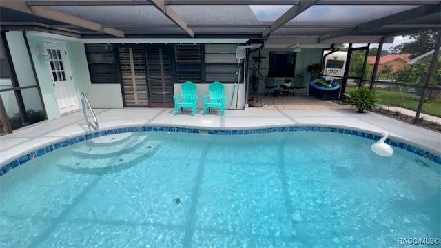 view of swimming pool with glass enclosure and a patio area