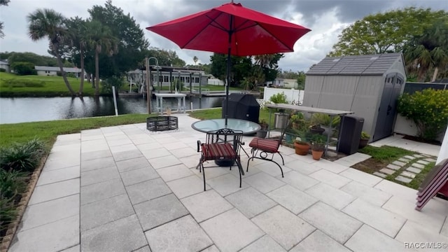 view of patio / terrace featuring a water view and a storage unit