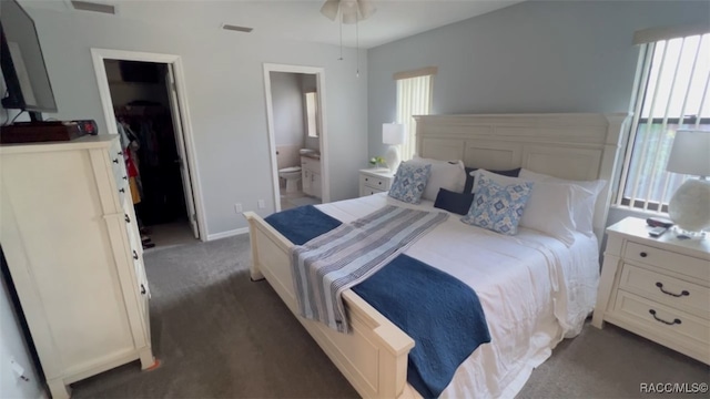 carpeted bedroom featuring ensuite bath, a walk in closet, and a closet