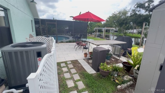 view of patio with central AC and a water view