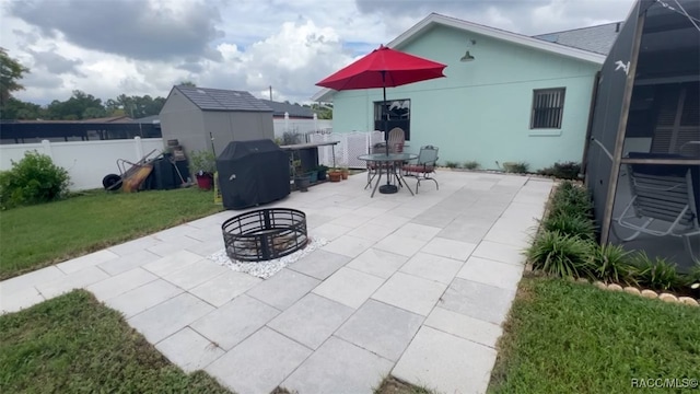 view of patio with a fire pit, a storage unit, and area for grilling