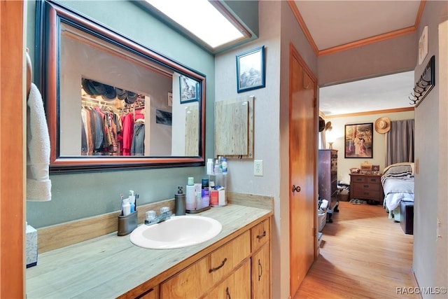 4200 W Breckenridge Ct, Beverly Hills, FL 34465 - ensuite bathroom featuring vanity, crown molding, wood finished floors, and a spacious closet
