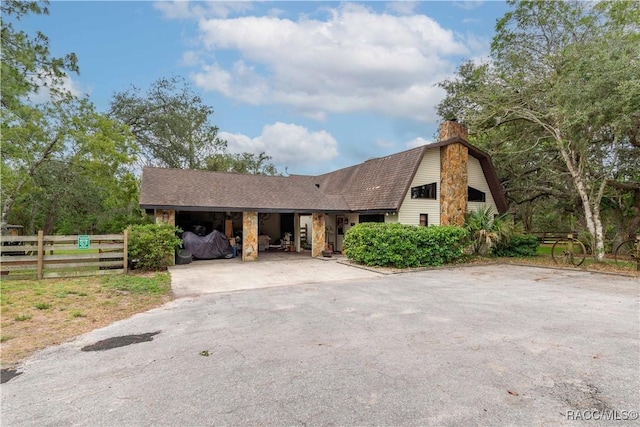 4200 W Breckenridge Ct, Beverly Hills, FL 34465 - view of front of home featuring a gambrel roof, a chimney, driveway, and roof with shingles