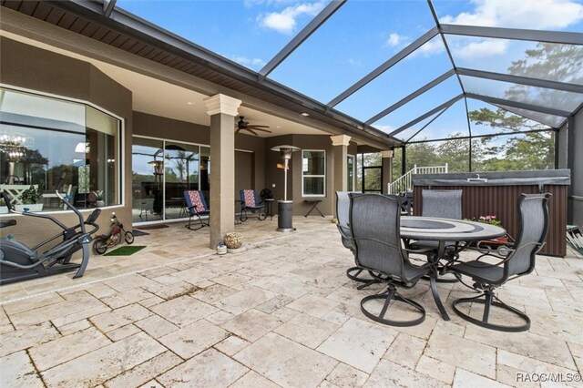 5061 W Oakhill St, Dunnellon, FL 34433 - view of patio / terrace with a hot tub, ceiling fan, outdoor dining area, and glass enclosure