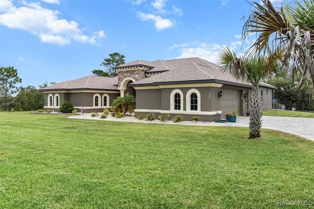 5061 W Oakhill St, Dunnellon, FL 34433 - mediterranean / spanish house with stucco siding, a garage, a front lawn, decorative driveway, and roof with shingles