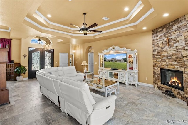 5061 W Oakhill St, Dunnellon, FL 34433 - living room featuring a tray ceiling, crown molding, arched walkways, ceiling fan, and french doors