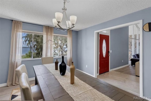 1316 Lake Ariana Blvd, Auburndale, FL 33823 - dining area featuring a chandelier, a textured ceiling, baseboards, and wood finished floors