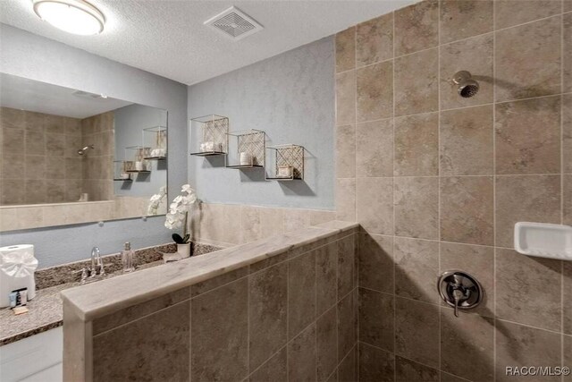 1316 Lake Ariana Blvd, Auburndale, FL 33823 - bathroom featuring tiled shower and a textured ceiling