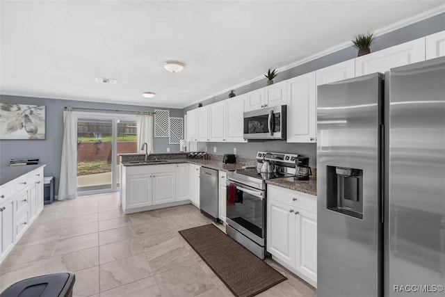 1316 Lake Ariana Blvd, Auburndale, FL 33823 - kitchen with appliances with stainless steel finishes, a sink, white cabinetry, dark stone counters, and light marble finish flooring