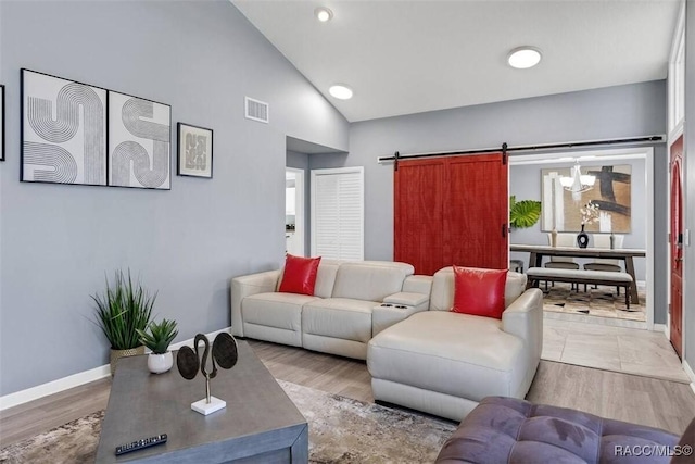1316 Lake Ariana Blvd, Auburndale, FL 33823 - living room featuring a barn door, baseboards, recessed lighting, wood finished floors, and high vaulted ceiling