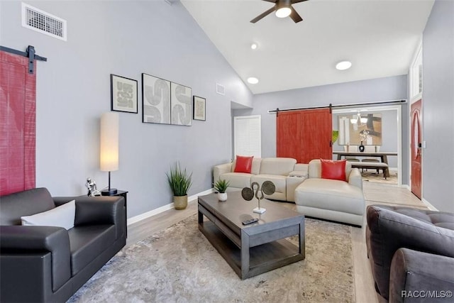 1316 Lake Ariana Blvd, Auburndale, FL 33823 - living area featuring a barn door, a ceiling fan, wood finished floors, baseboards, and high vaulted ceiling
