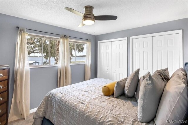 1316 Lake Ariana Blvd, Auburndale, FL 33823 - bedroom with two closets, carpet flooring, baseboards, a ceiling fan, and a textured ceiling
