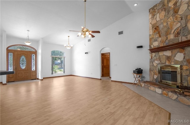 3565 S Oakdale Ter, Inverness, FL 34452 - unfurnished living room featuring high vaulted ceiling, ceiling fan with notable chandelier, a fireplace, and light hardwood / wood-style floors