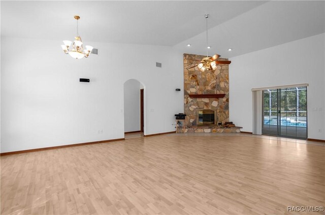3565 S Oakdale Ter, Inverness, FL 34452 - unfurnished living room with high vaulted ceiling, ceiling fan with notable chandelier, a fireplace, and light hardwood / wood-style flooring