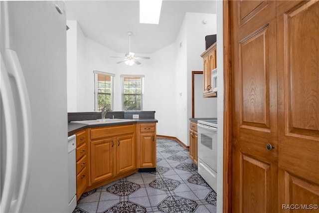 3565 S Oakdale Ter, Inverness, FL 34452 - kitchen with light tile patterned flooring, lofted ceiling with skylight, sink, white appliances, and ceiling fan