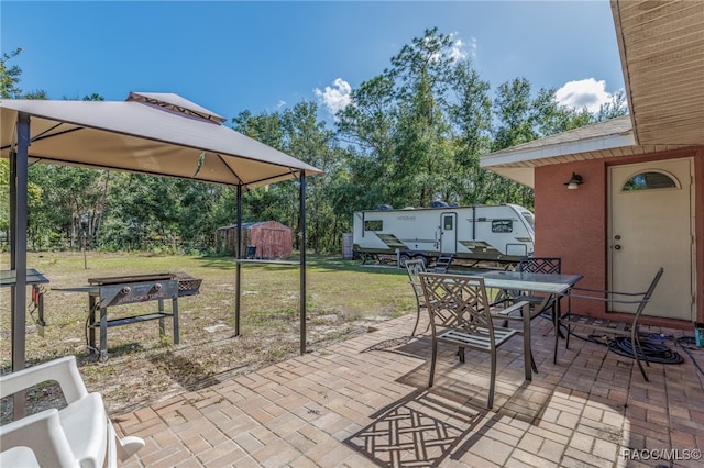 view of patio / terrace with a gazebo and a storage unit