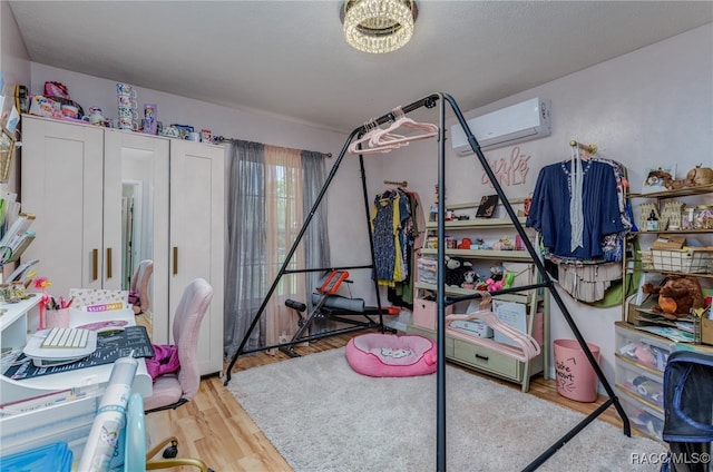 bedroom featuring wood-type flooring and a wall mounted air conditioner