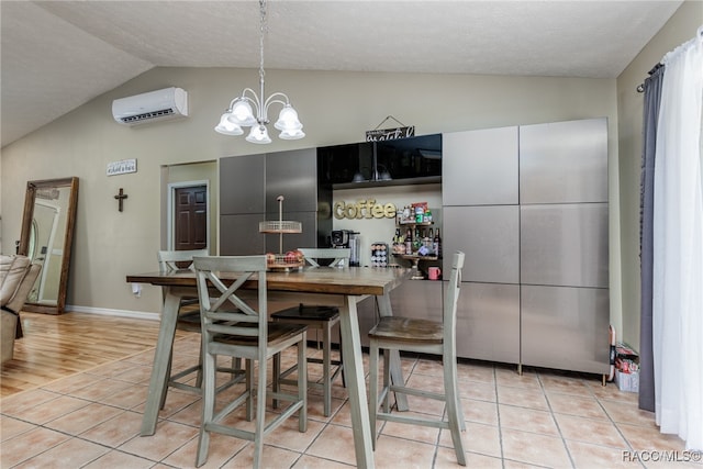 kitchen with lofted ceiling, hanging light fixtures, light hardwood / wood-style flooring, a textured ceiling, and a wall mounted AC