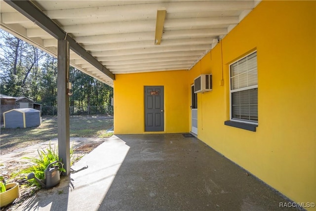 view of patio with a shed and a wall unit AC