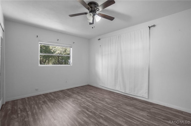 unfurnished room featuring dark wood-type flooring and ceiling fan