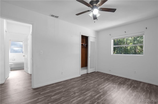 unfurnished bedroom with dark hardwood / wood-style flooring, a closet, and ceiling fan