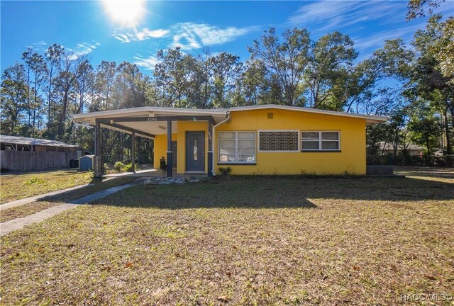 view of front of property featuring a front yard and a carport