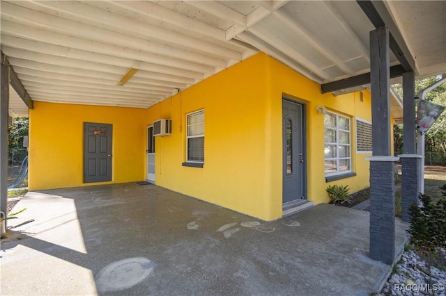 view of patio featuring an AC wall unit and a carport