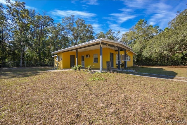 rear view of house featuring a lawn