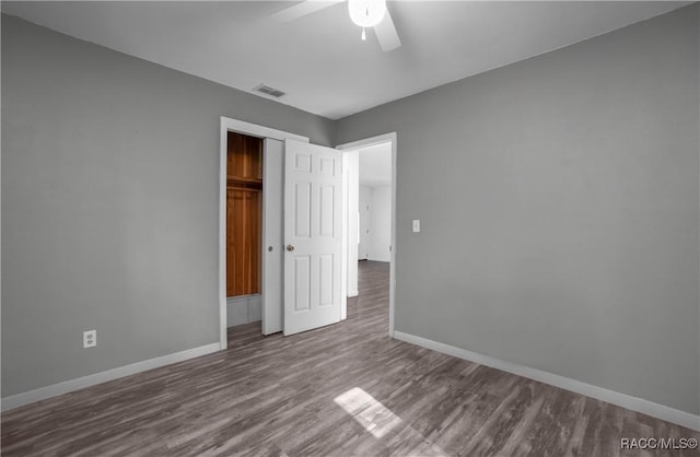 unfurnished bedroom with ceiling fan, hardwood / wood-style floors, and a closet